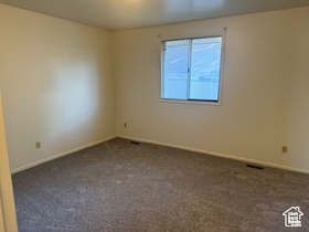 Carpeted spare room with baseboards