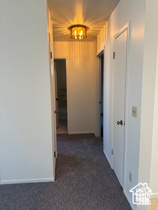 Hallway featuring carpet and baseboards