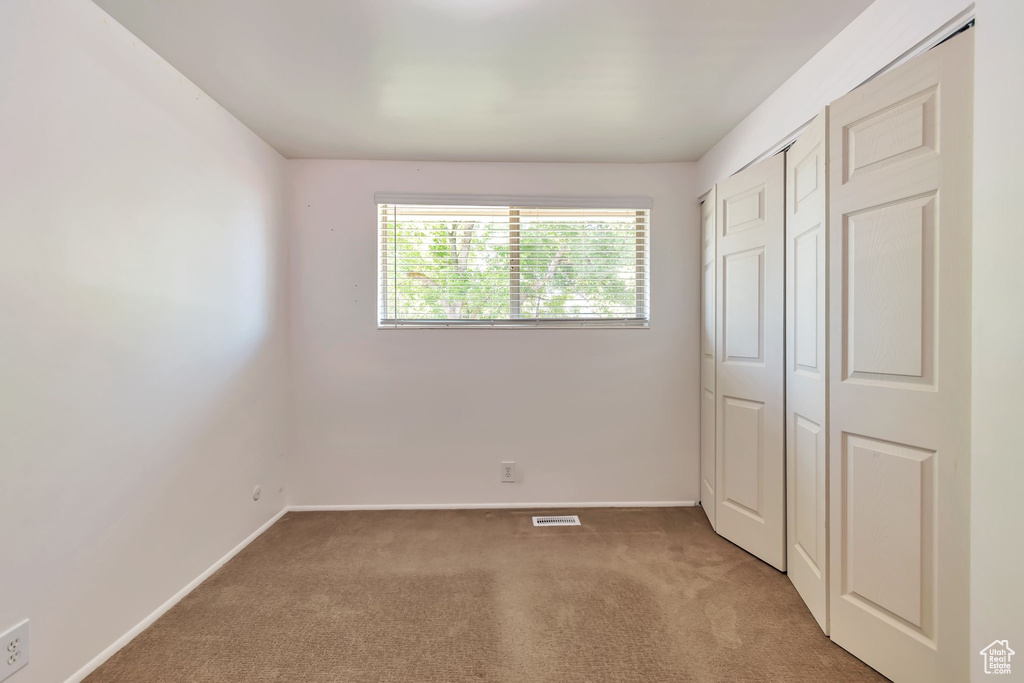 Unfurnished bedroom featuring carpet floors and a closet