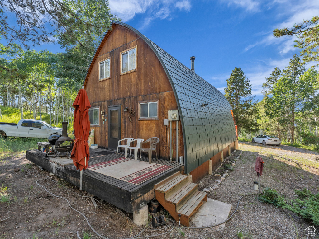 Rear view of house with a gambrel roof and a deck