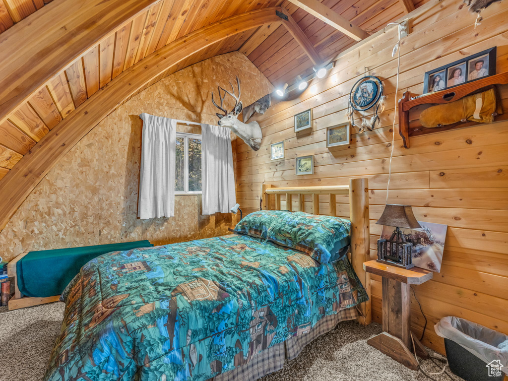 Bedroom featuring wood ceiling, carpet floors, and wood walls