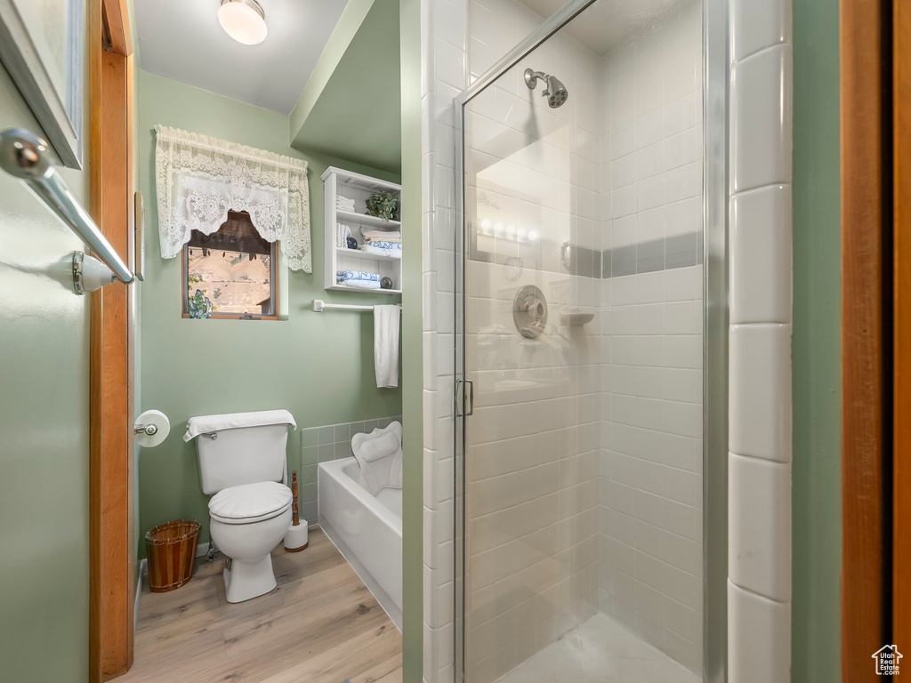Full bathroom featuring a shower stall, wood finished floors, and a bath