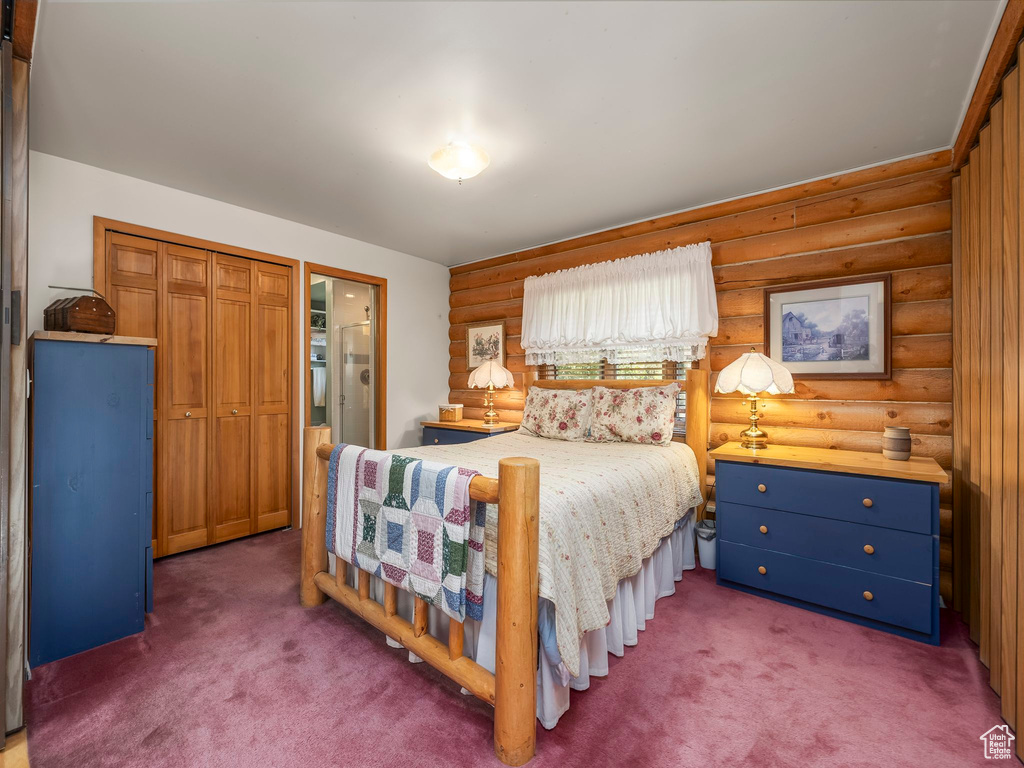 Carpeted bedroom featuring log walls