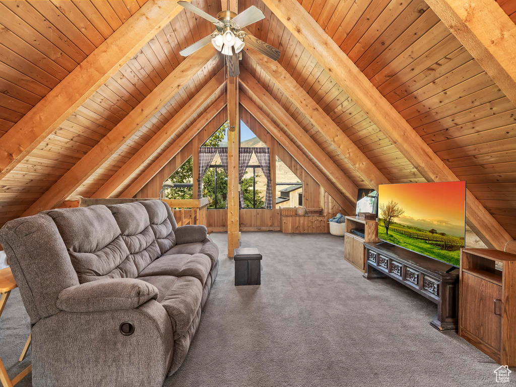 Living area with wood ceiling, carpet flooring, a ceiling fan, and wooden walls