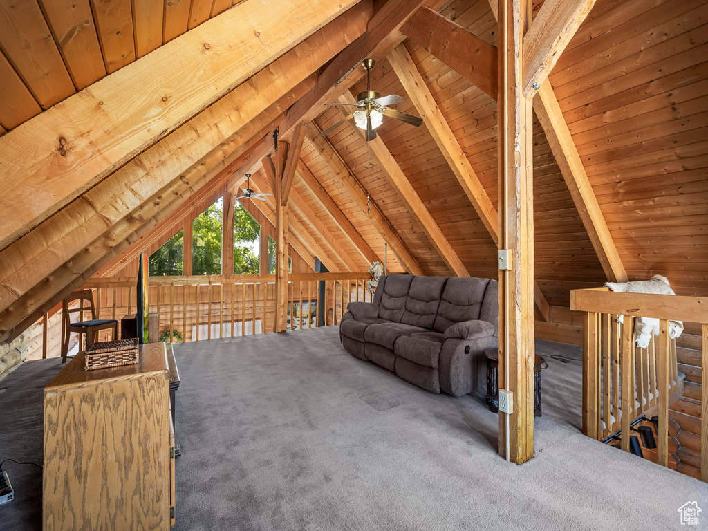 Unfurnished living room featuring ceiling fan, wooden ceiling, and carpet flooring