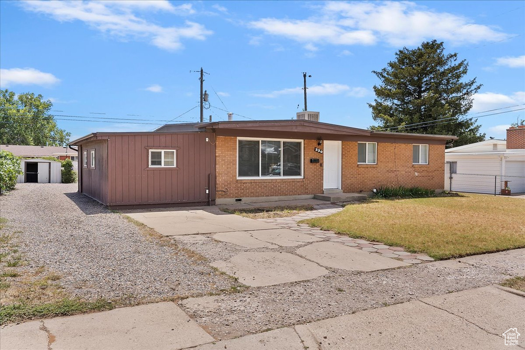 Ranch-style house with brick siding, driveway, and crawl space