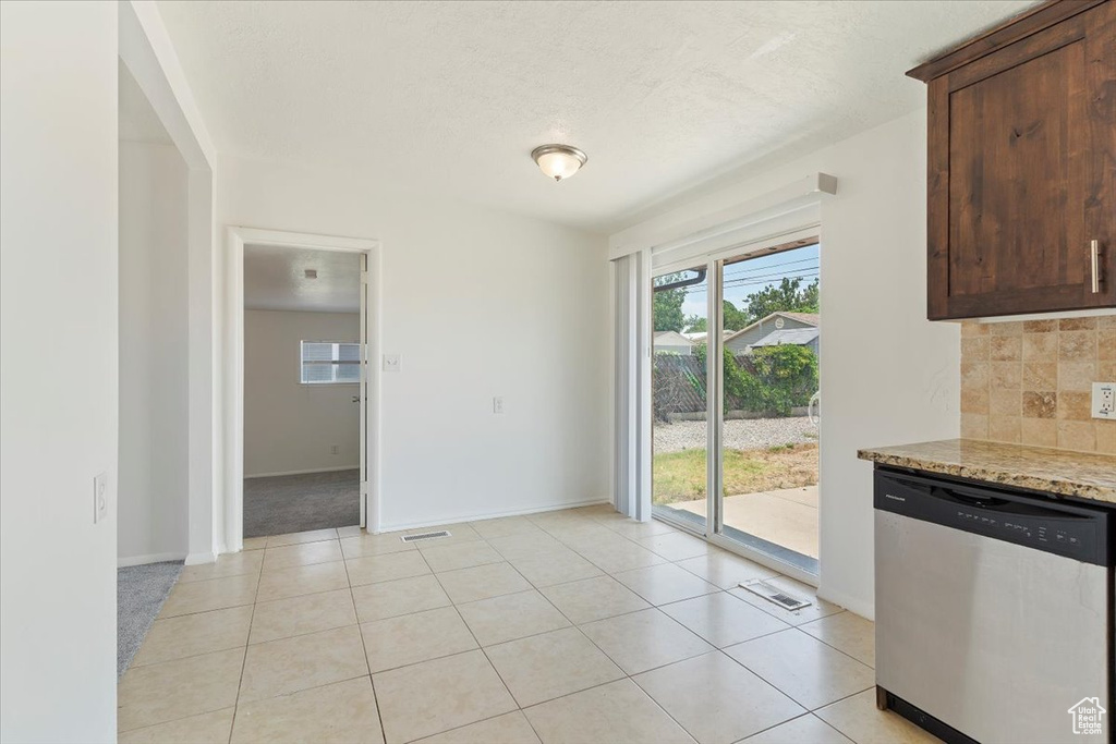 Unfurnished dining area with baseboards and light tile patterned floors