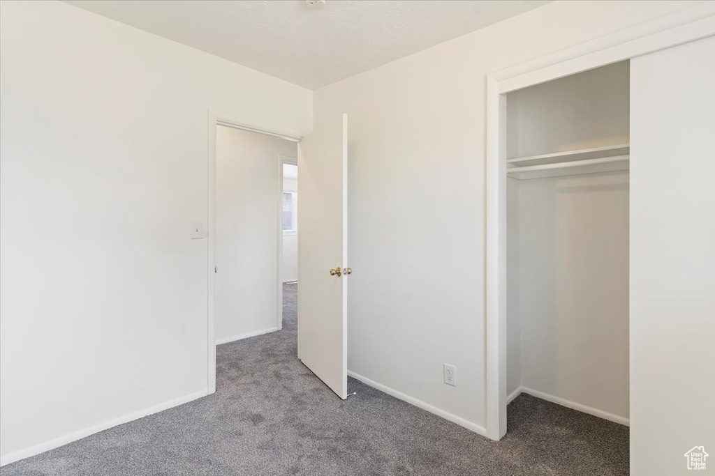 Unfurnished bedroom featuring carpet flooring and a closet