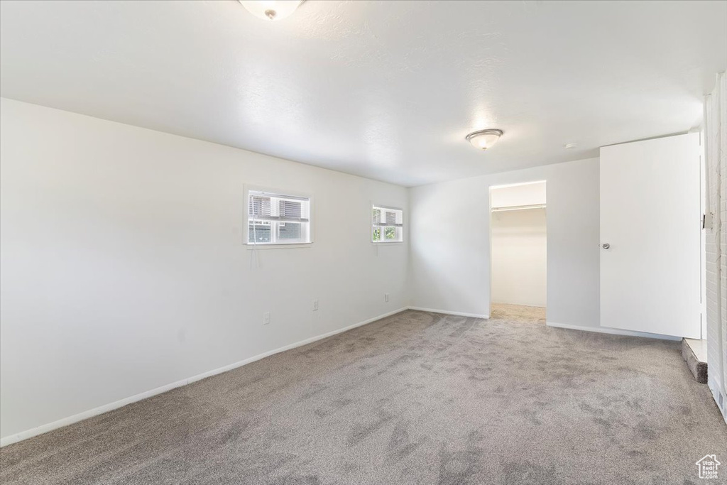 Unfurnished room featuring light colored carpet and baseboards