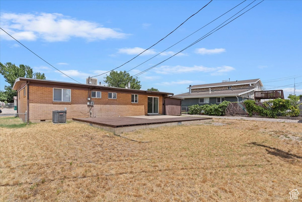 Back of house featuring brick siding and a wooden deck