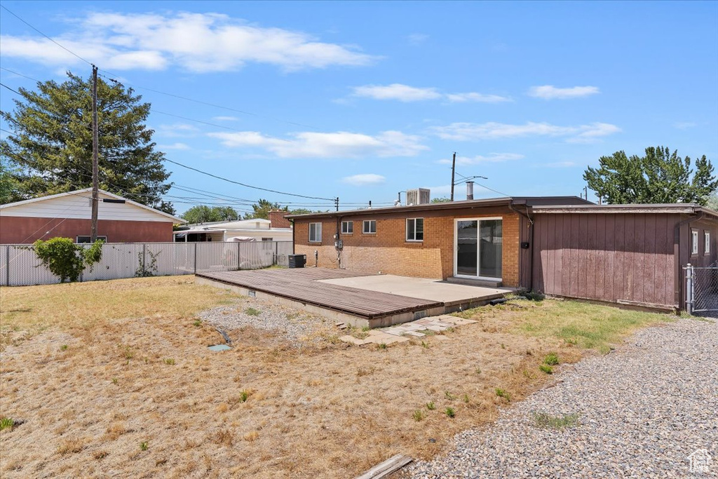 Back of property with a wooden deck and brick siding