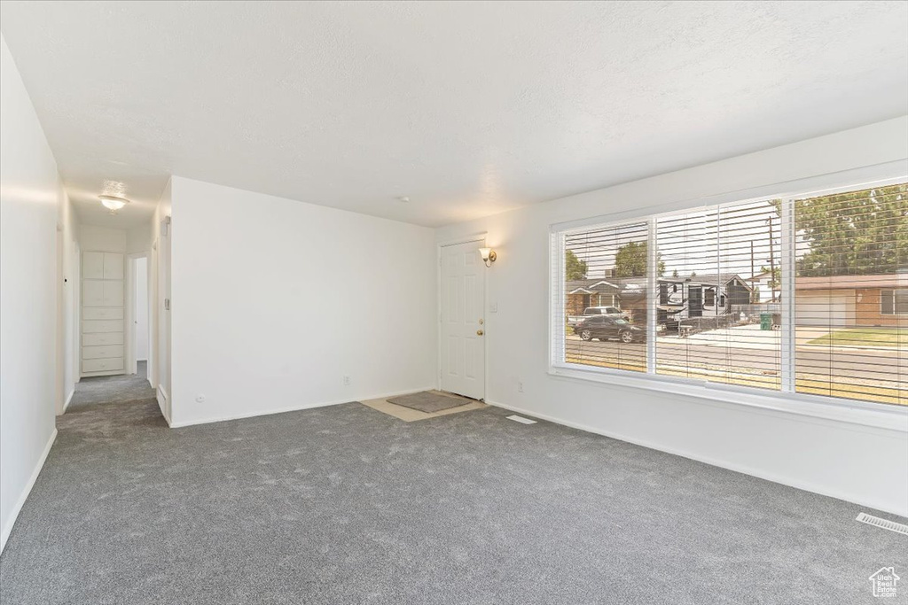 Carpeted empty room with baseboards