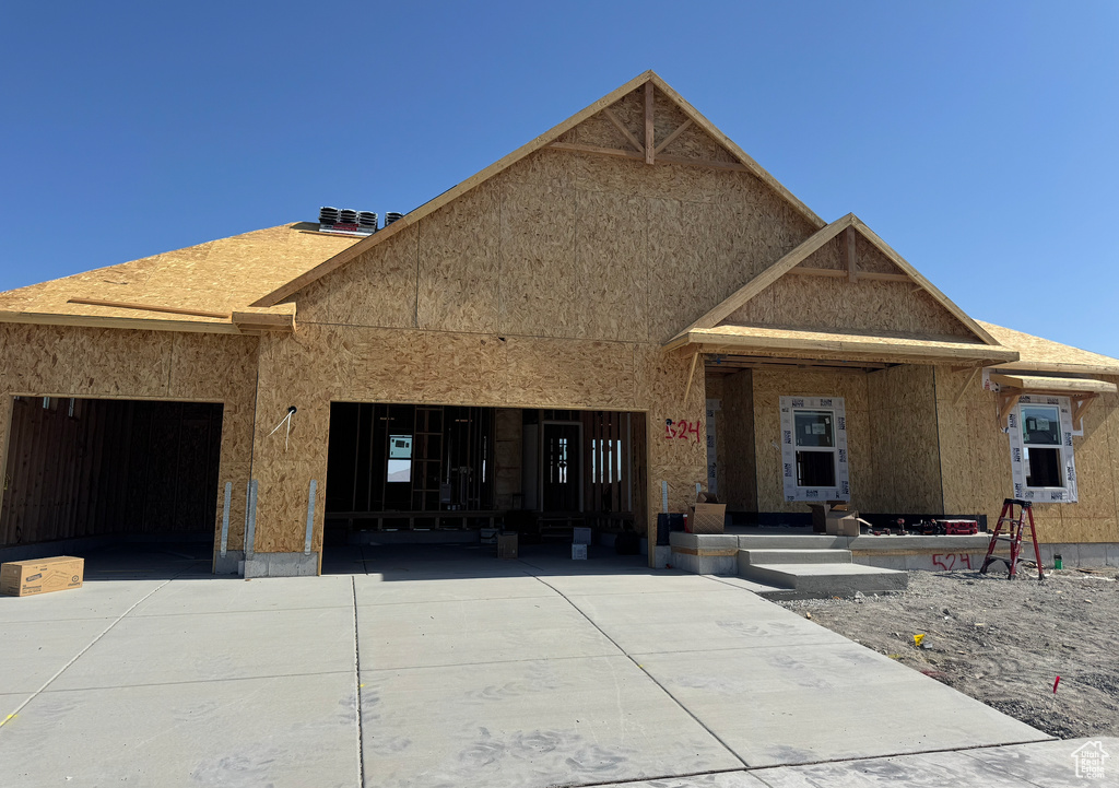Unfinished property with concrete driveway and an attached garage
