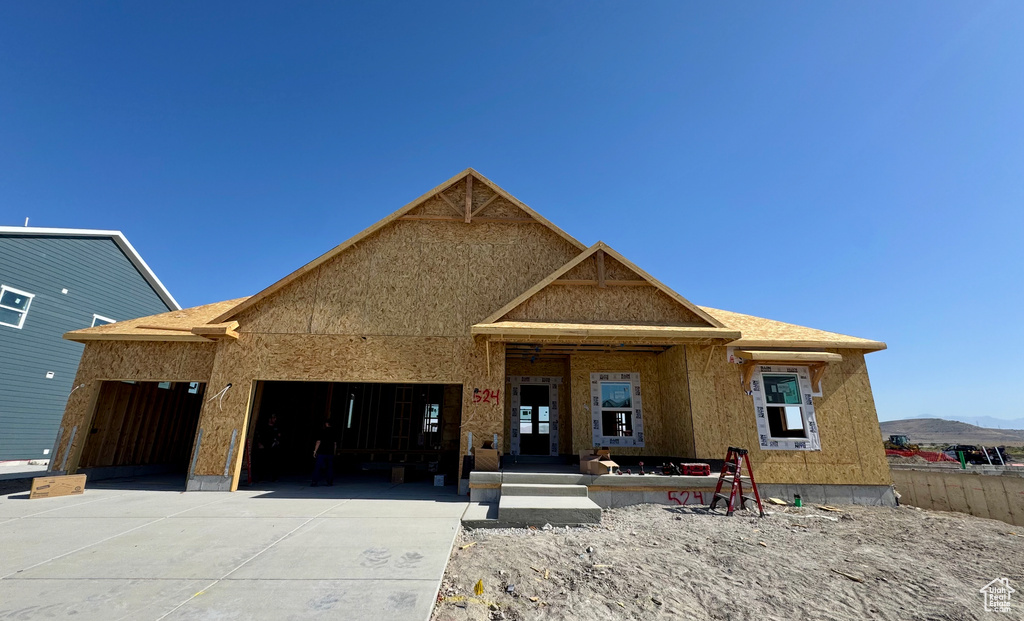 Property under construction with concrete driveway, an attached garage, and a mountain view