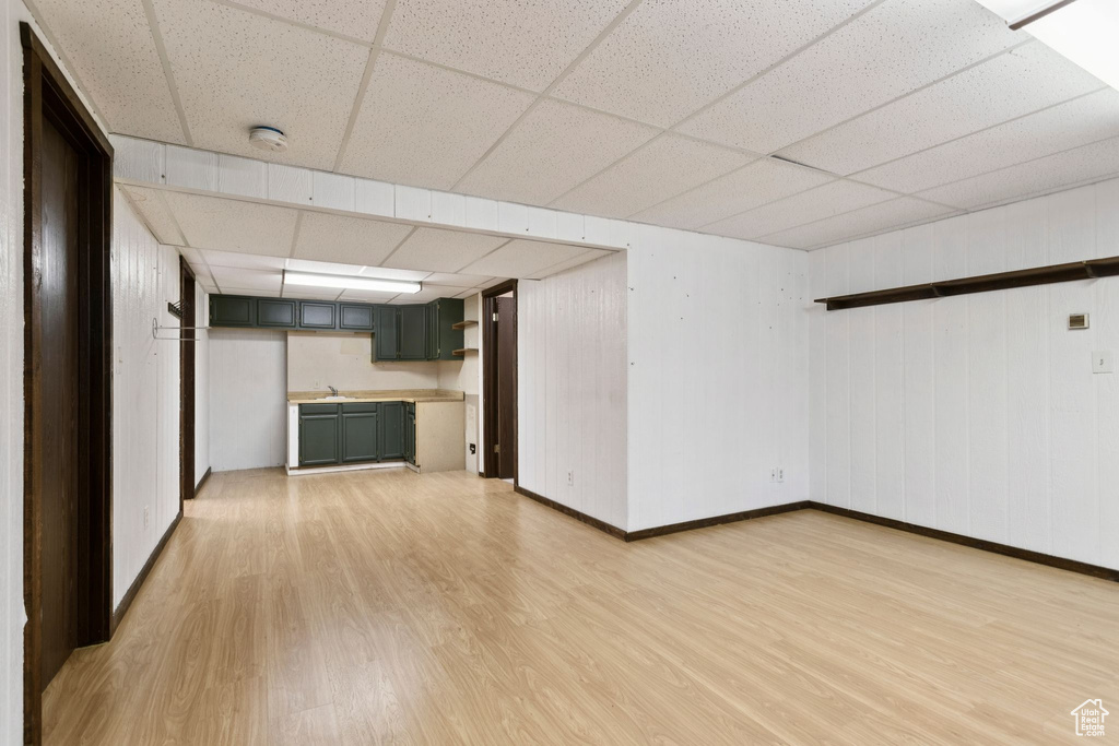 Finished basement featuring light wood-style flooring and a paneled ceiling