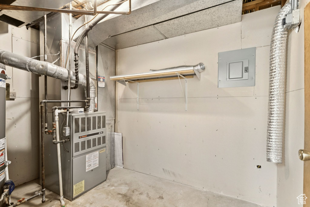 Utility room featuring heating unit and electric panel