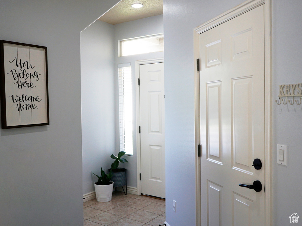 Entrance foyer featuring light tile patterned flooring and baseboards