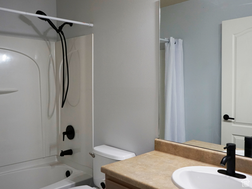 Bathroom featuring vanity and shower / bath combination with curtain