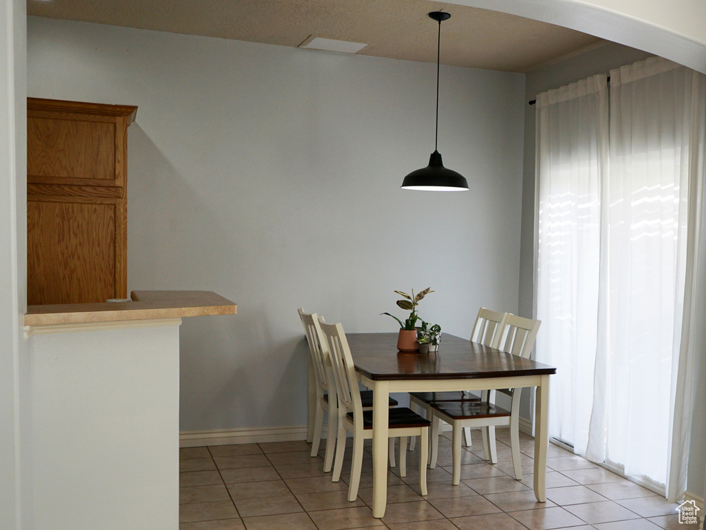 Dining room with light tile patterned floors and arched walkways