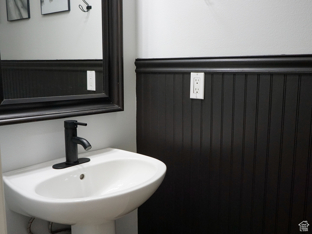 Bathroom with a sink and a wainscoted wall