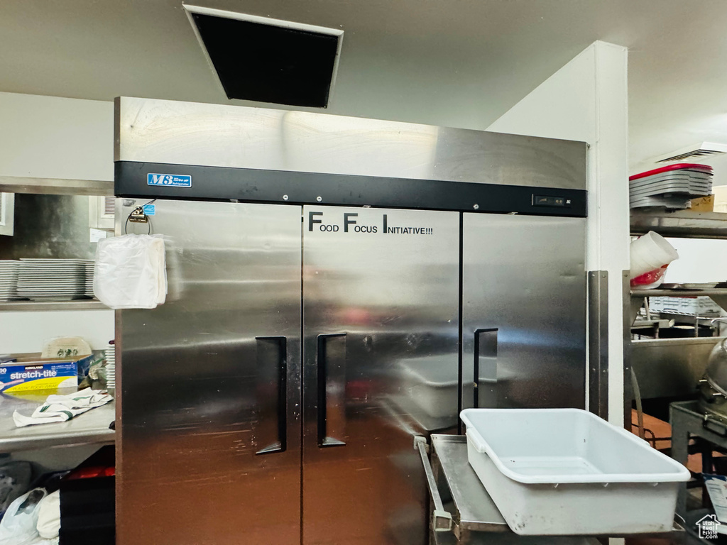 Kitchen featuring wall chimney exhaust hood and dark tile patterned flooring