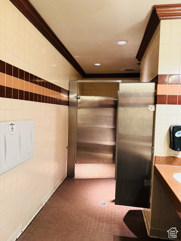 Bathroom featuring tile walls, ornamental molding, vanity, and recessed lighting