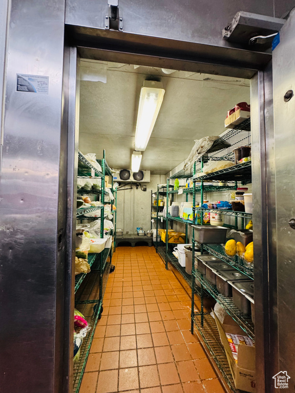 Kitchen featuring refrigerator and dark tile patterned flooring