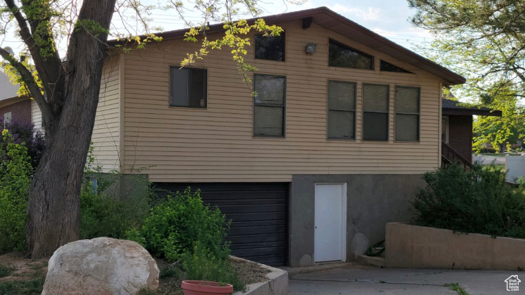 View of front of home with an attached garage, stucco siding, and concrete driveway