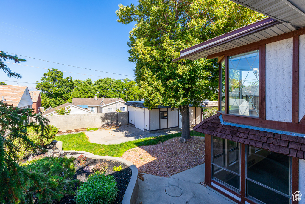Fenced backyard featuring a patio area and a storage unit