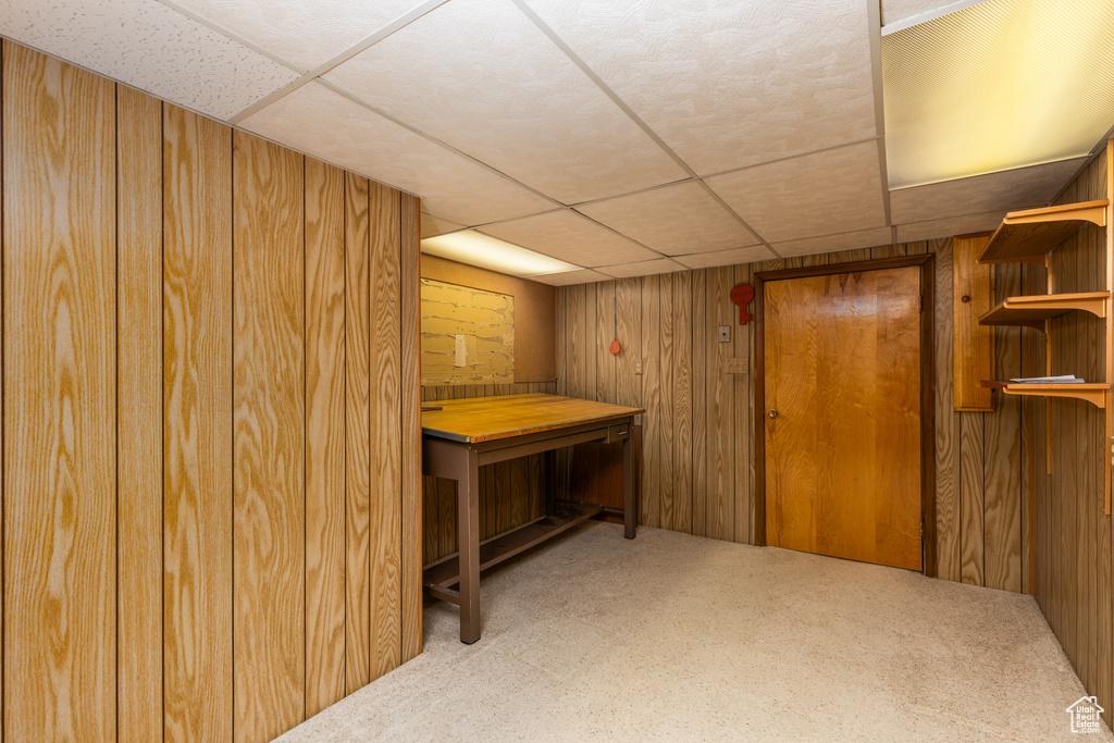 Bar area featuring a paneled ceiling, carpet flooring, and wooden walls