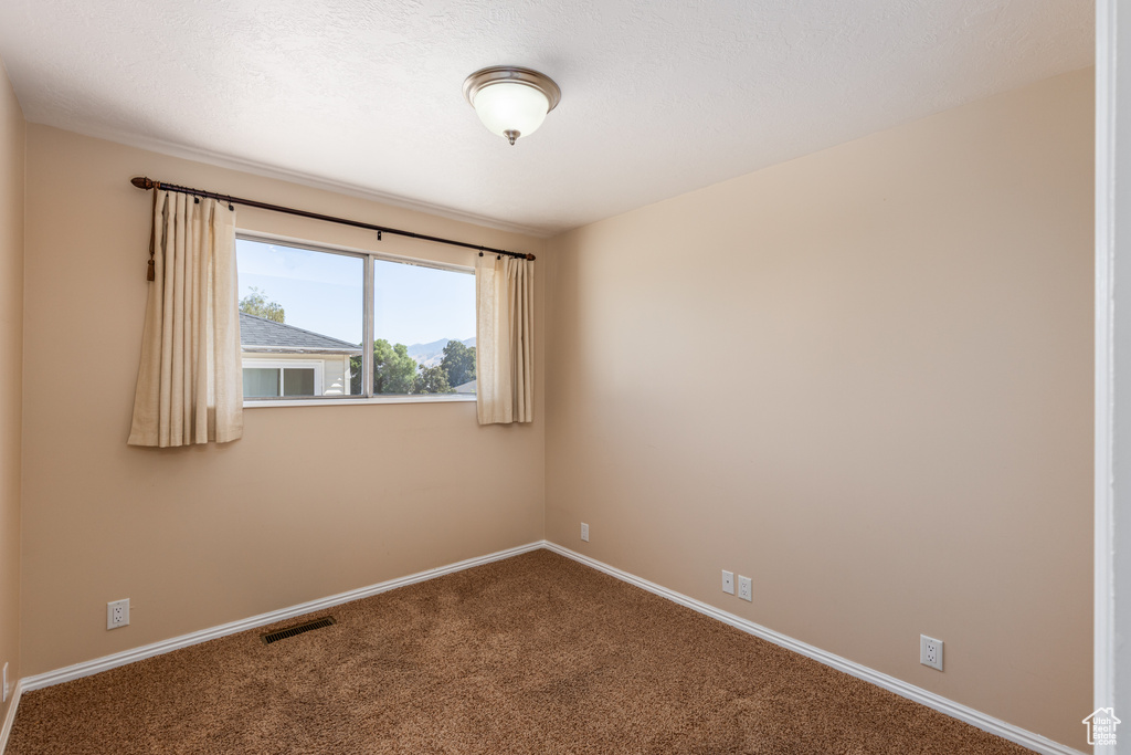 Unfurnished room featuring carpet and baseboards