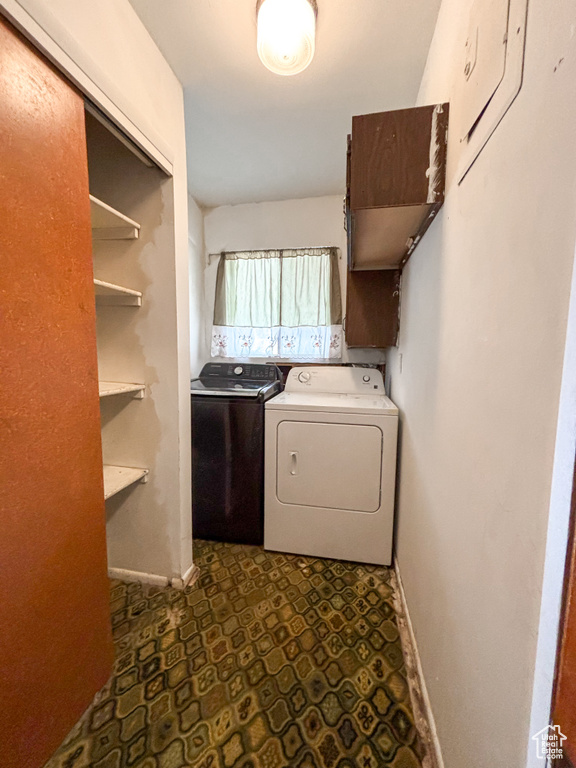 Laundry area with dark flooring and washing machine and clothes dryer