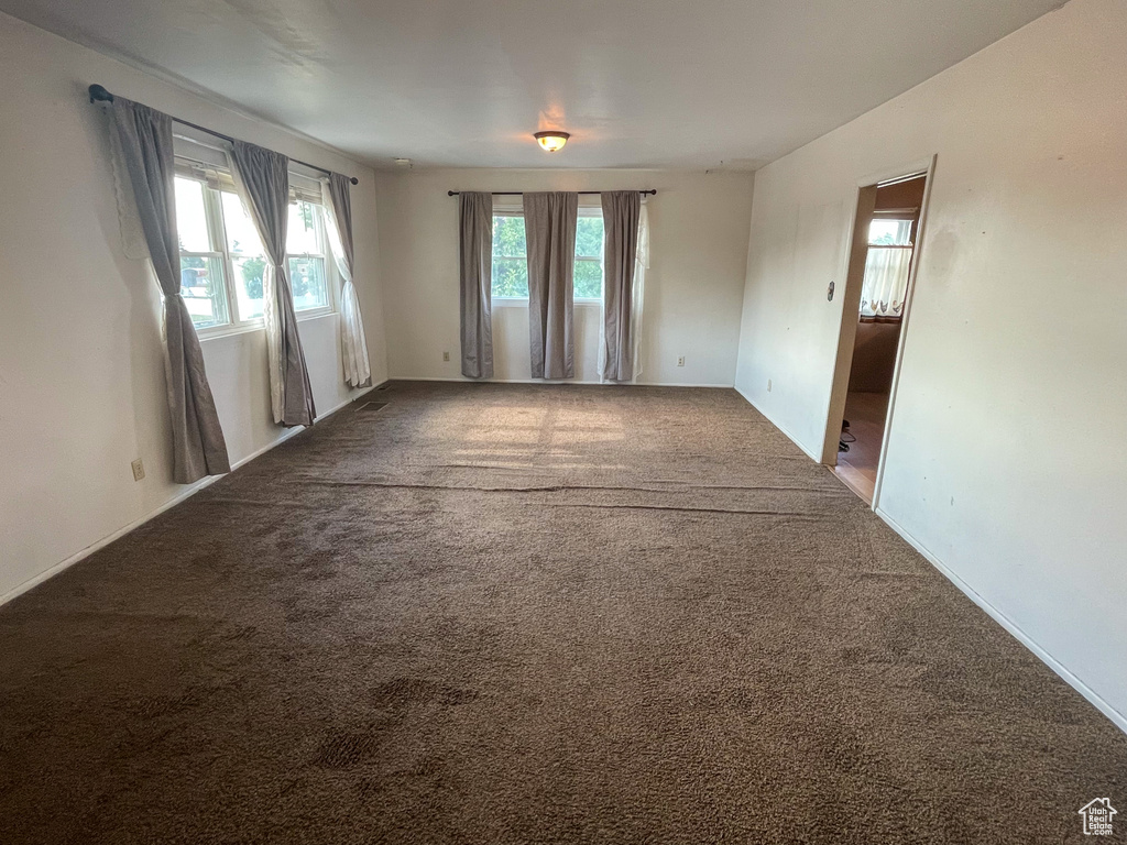 Carpeted empty room featuring baseboards