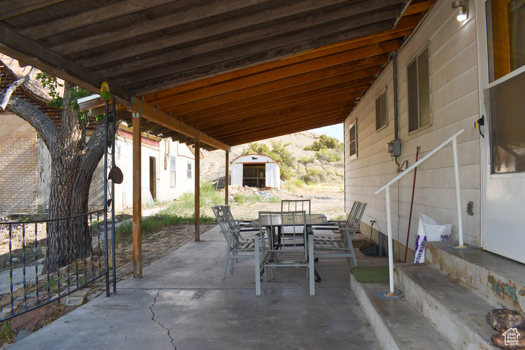 View of patio / terrace with a storage unit, outdoor dining area, and entry steps