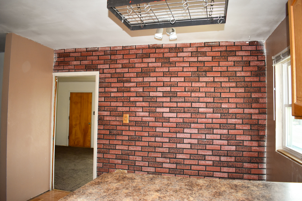 Spare room featuring brick wall