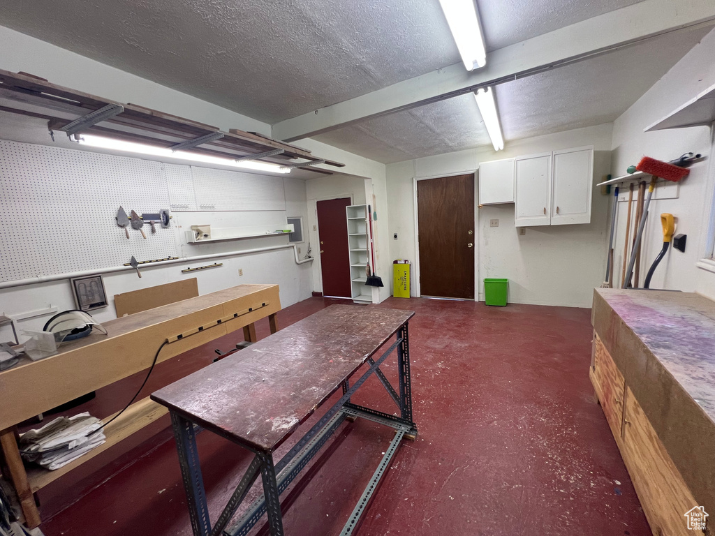 Basement with a workshop area and a textured ceiling