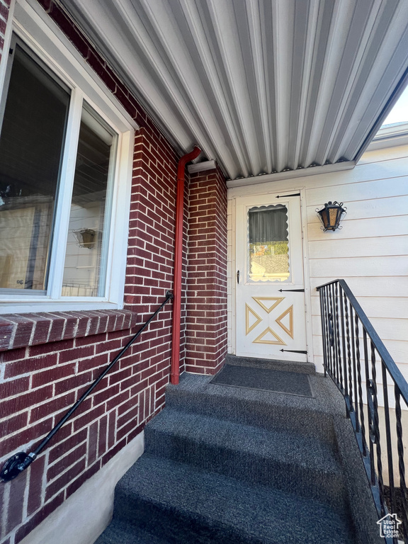 Doorway to property featuring brick siding