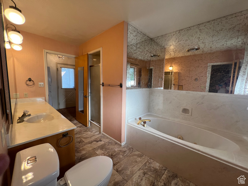 Full bathroom featuring a stall shower, a whirlpool tub, and double vanity