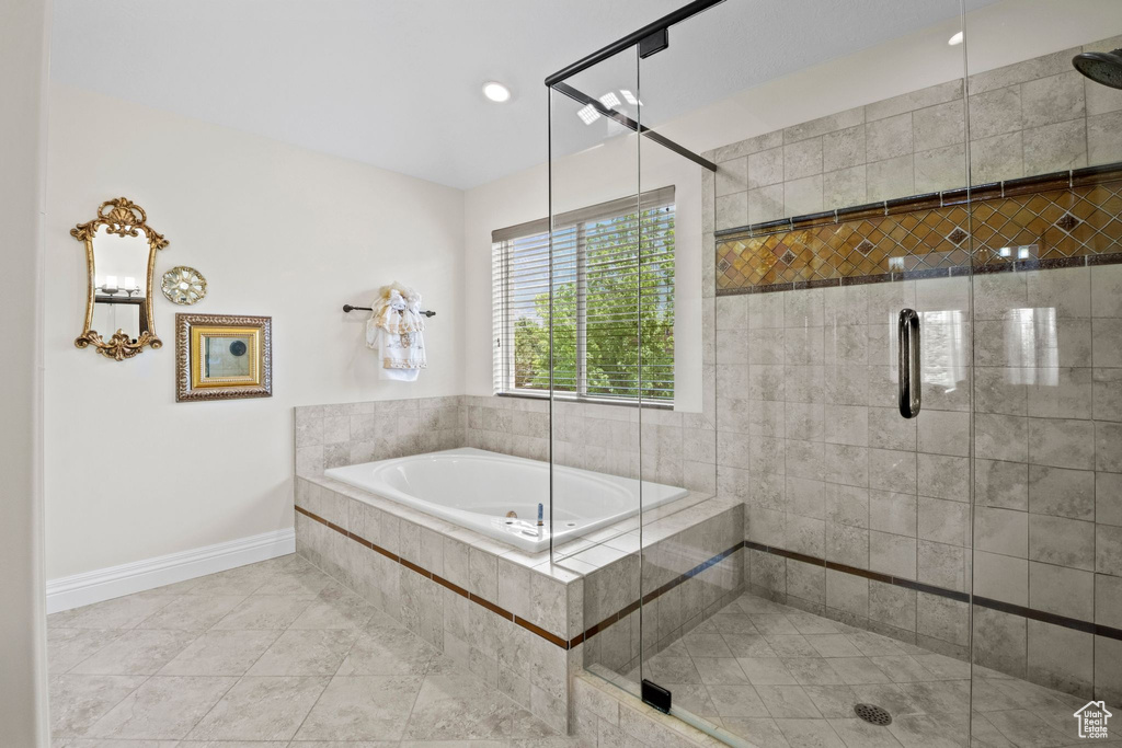 Bathroom with a stall shower, a bath, and tile patterned flooring