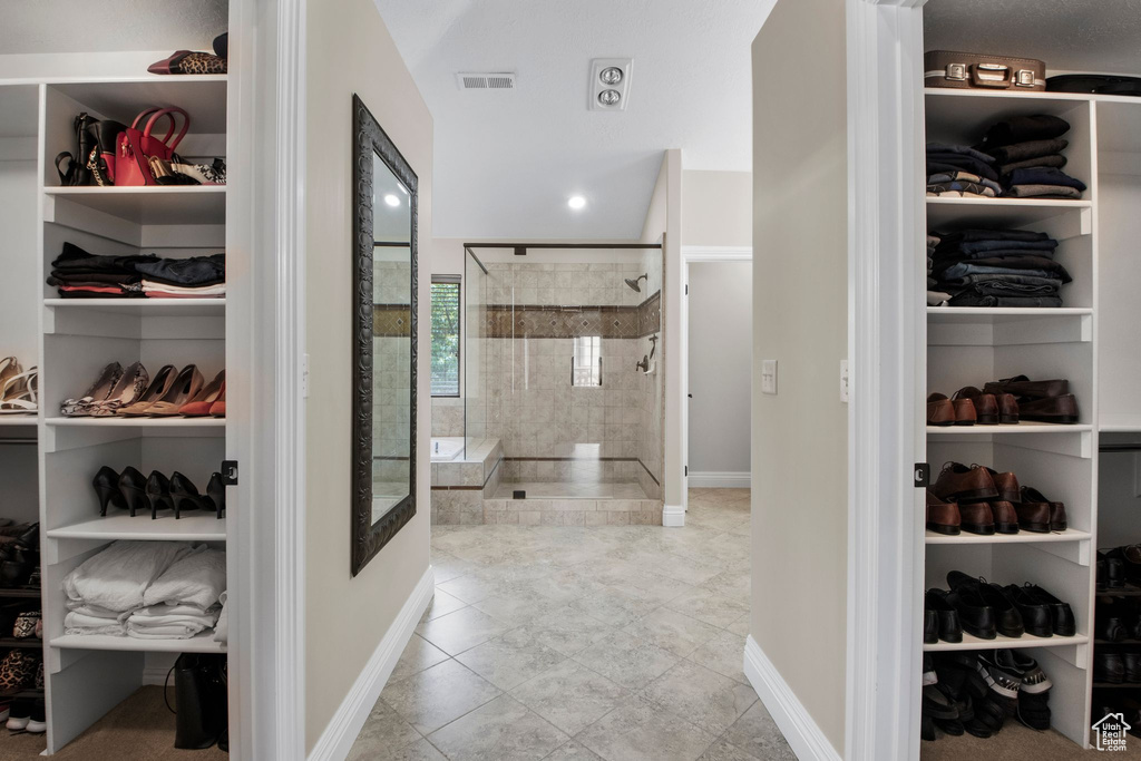 Full bathroom featuring tiled shower, a walk in closet, and tile patterned floors