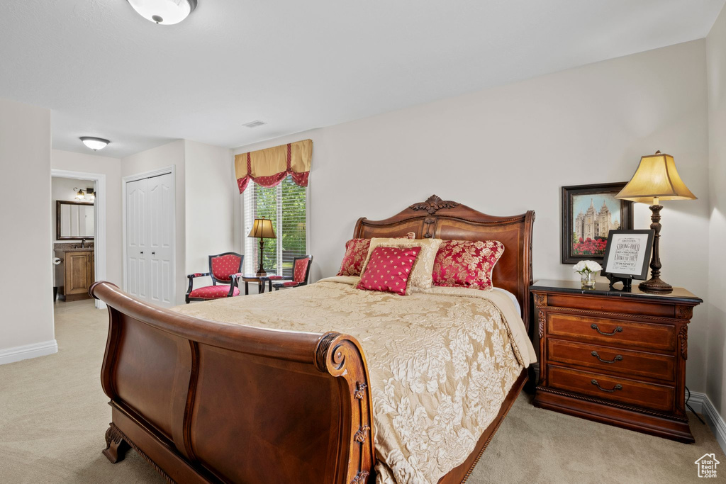 Bedroom featuring light colored carpet and a closet