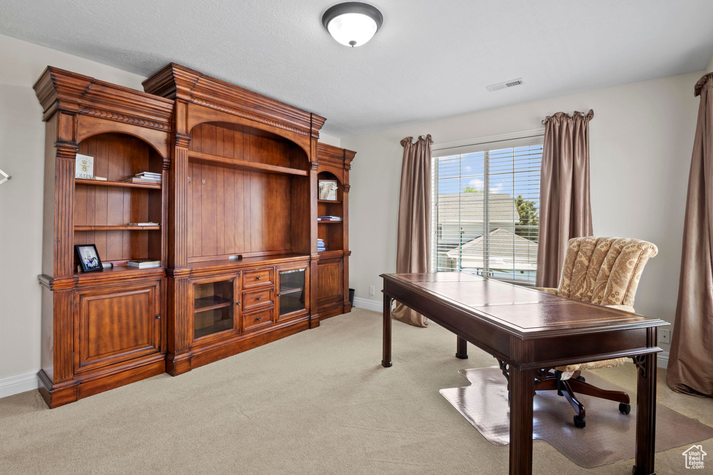 Office space with light colored carpet and baseboards