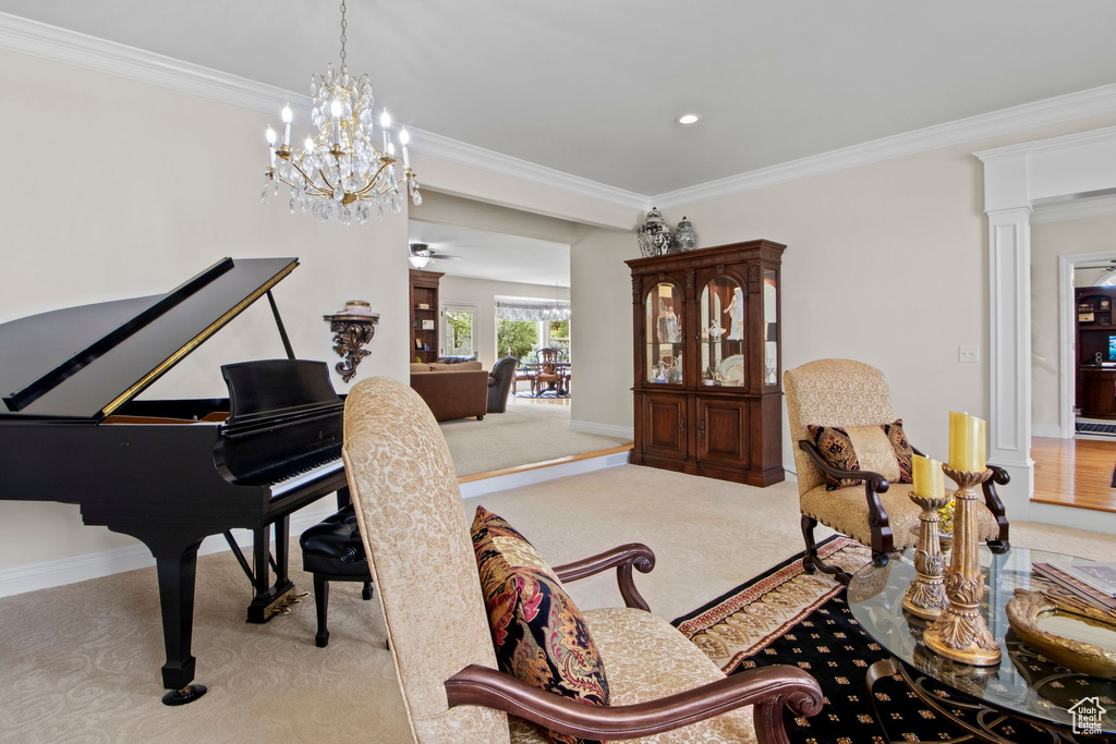 Sitting room featuring carpet floors, crown molding, decorative columns, a chandelier, and recessed lighting