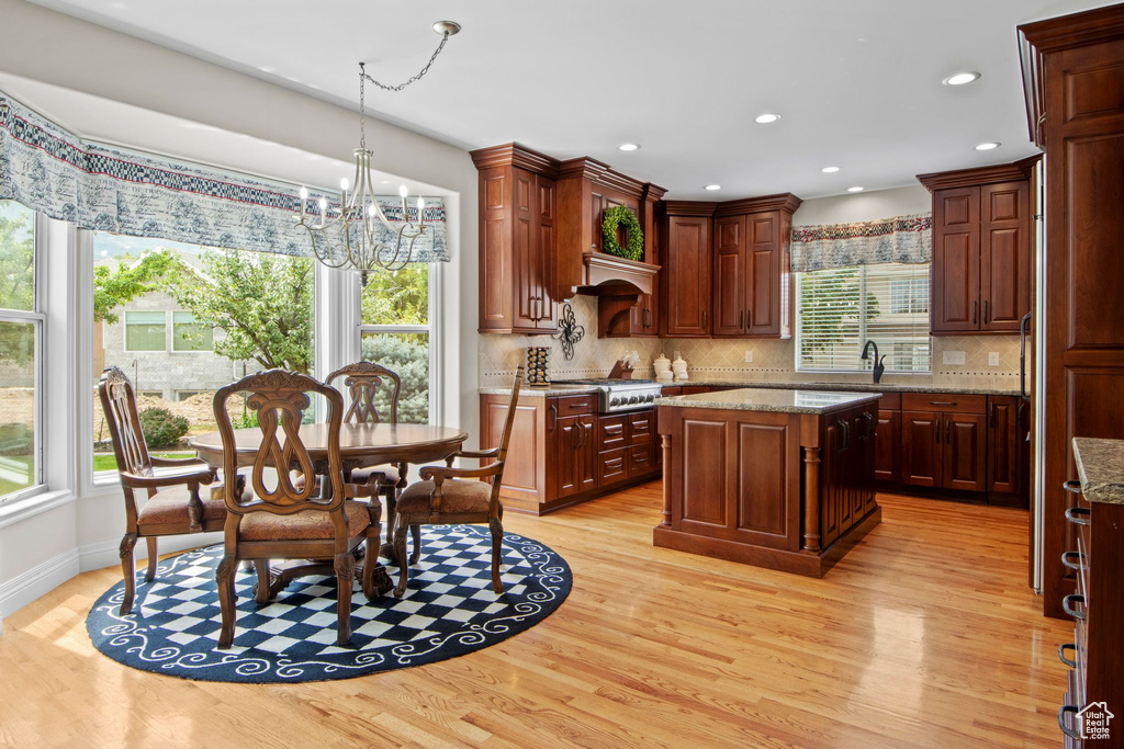 Kitchen featuring a chandelier, stainless steel gas cooktop, light wood-style floors, tasteful backsplash, and recessed lighting