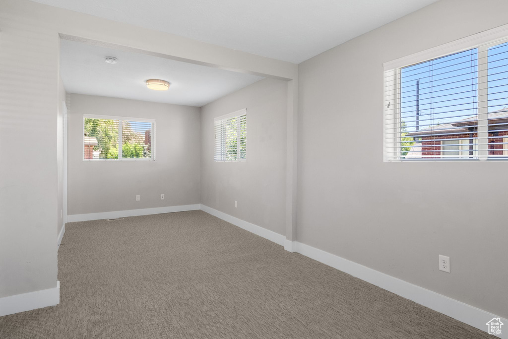 Empty room featuring carpet and a smoke detector