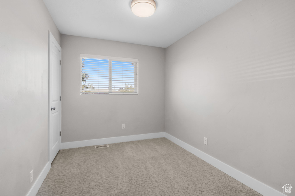 Carpeted empty room with baseboards