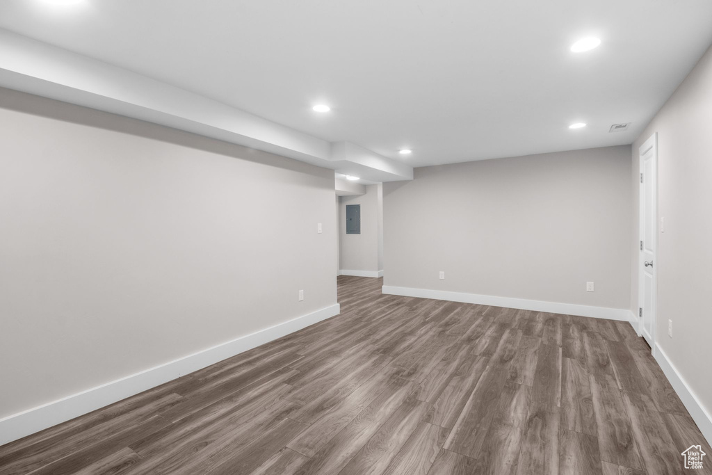 Finished below grade area featuring recessed lighting, dark wood finished floors, and electric panel