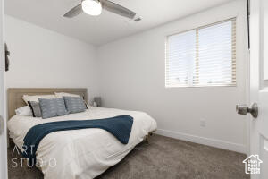Carpeted bedroom featuring baseboards and a ceiling fan