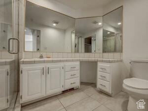 Bathroom with vanity, tile patterned flooring, and a stall shower