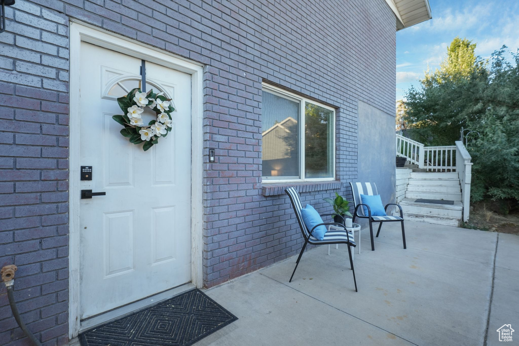 Property entrance with brick siding and a patio